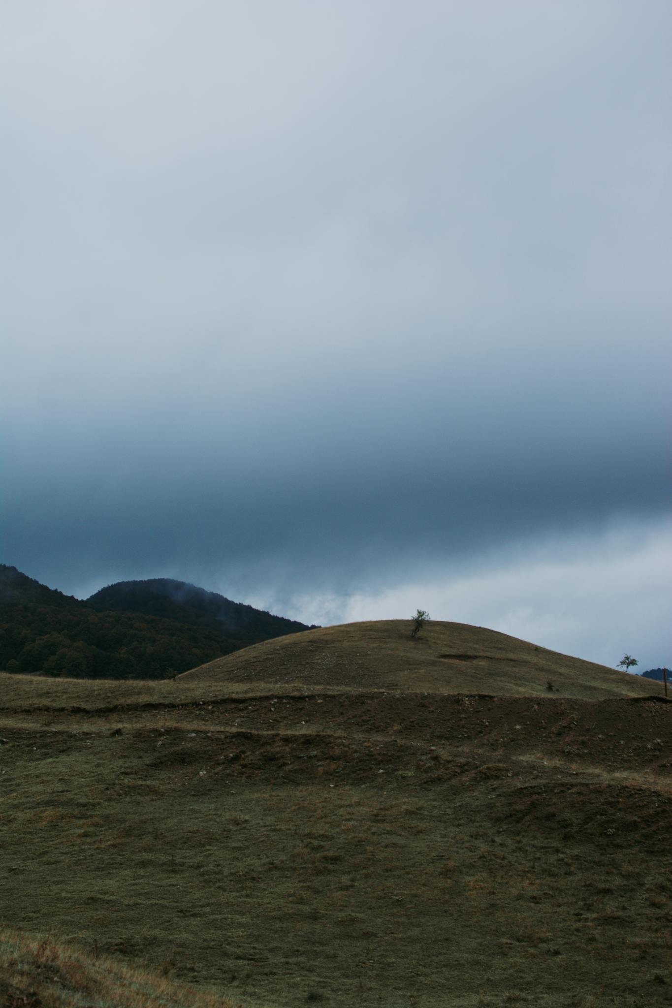 A serene landscape showcasing rolling hills and moody clouds, perfect for peaceful outdoor themes.