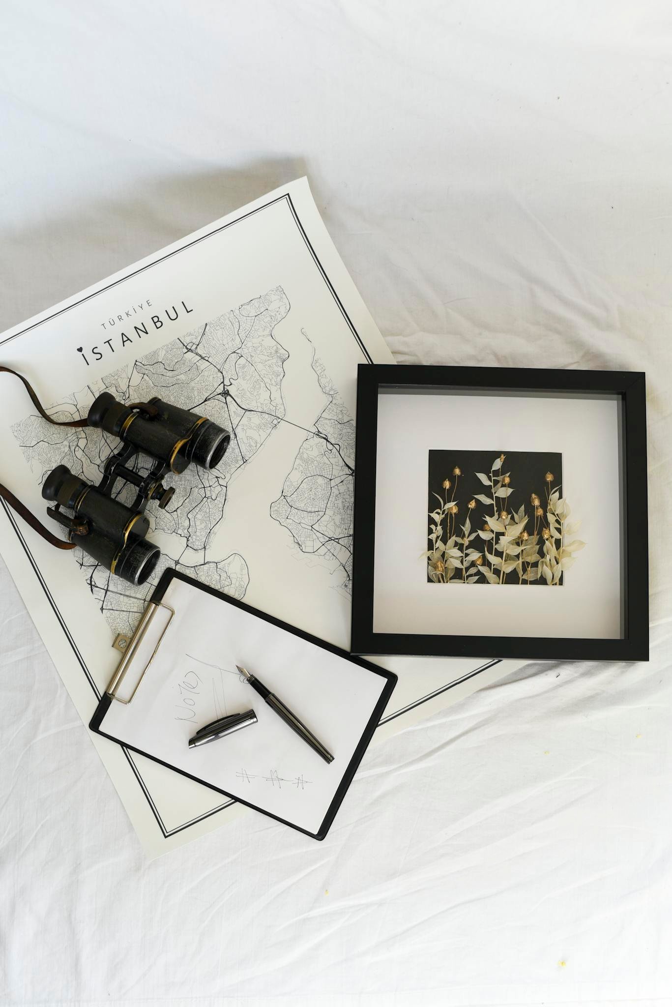 Flat lay featuring a map of Istanbul, binoculars, and a notebook for travel planning.
